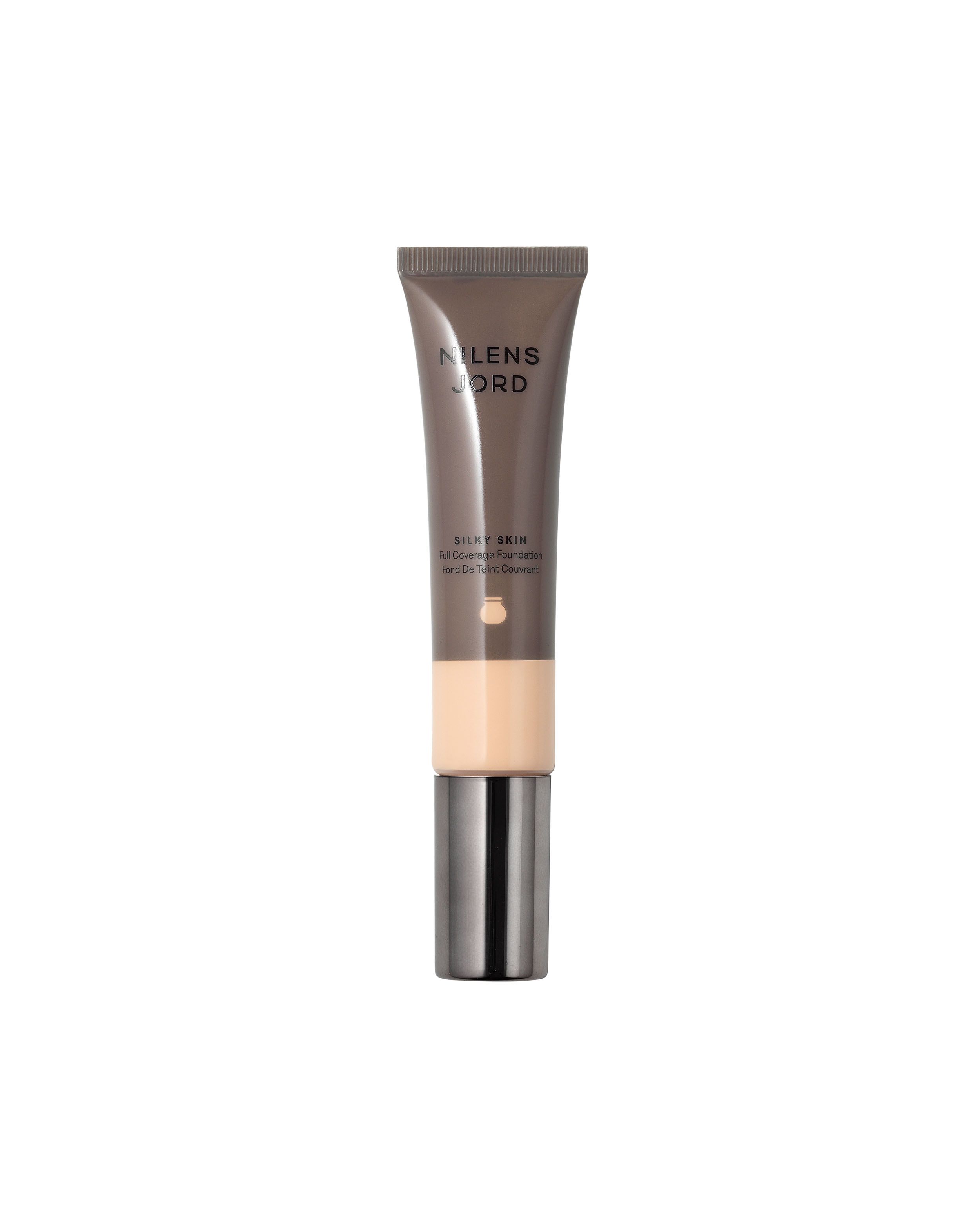 Nilens Jord Silky Skin Foundation in einem schmalen Spender. Helle Hautfarbe sichtbar.