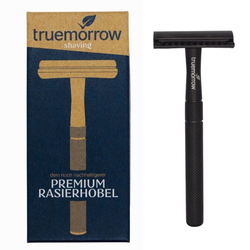 Schwarzer Rasierhobel aus Metall. Neben der Verpackung mit dem Markennamen truemorrow. Aufschrift: Premium Rasierhobel.