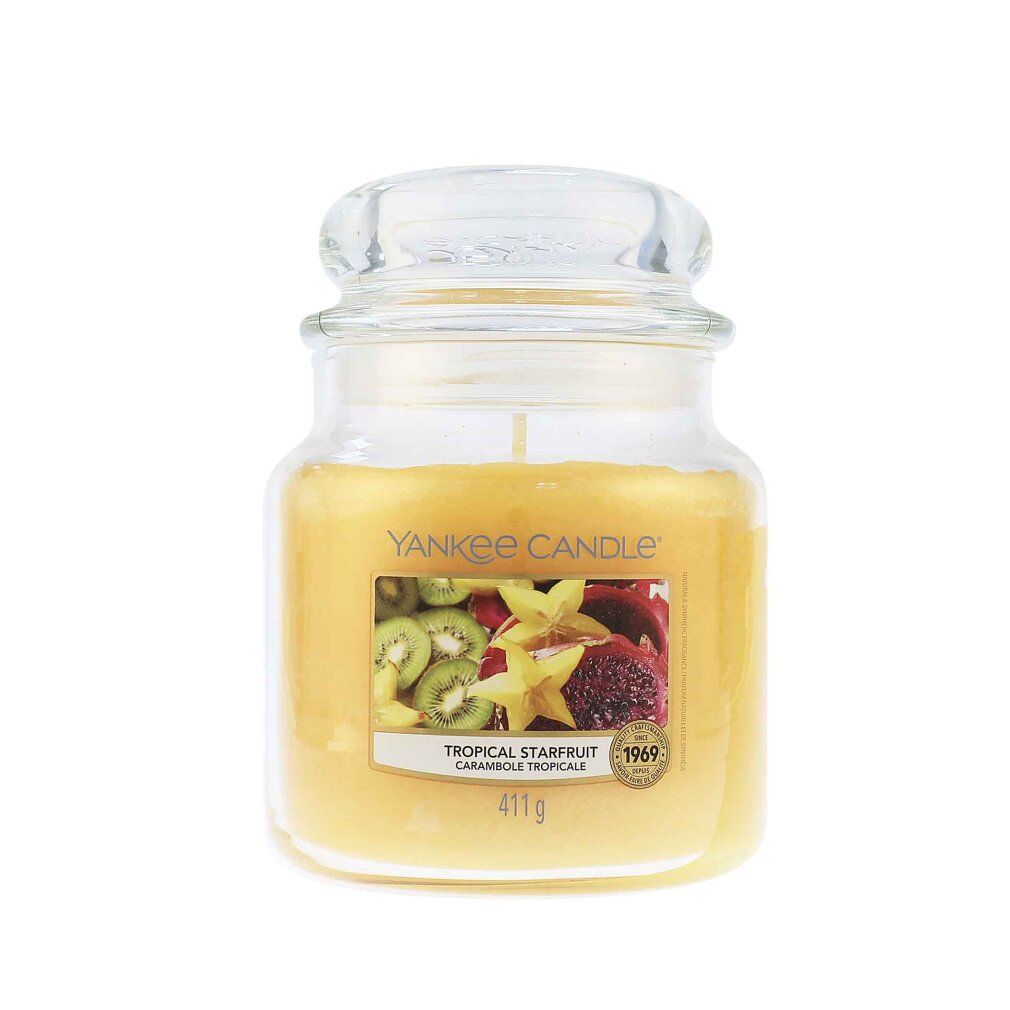 Glasbehälter mit gelbem Wachs und Deckel. Etikett mit Früchten und Schriftzug Tropical Starfruit. 411g.