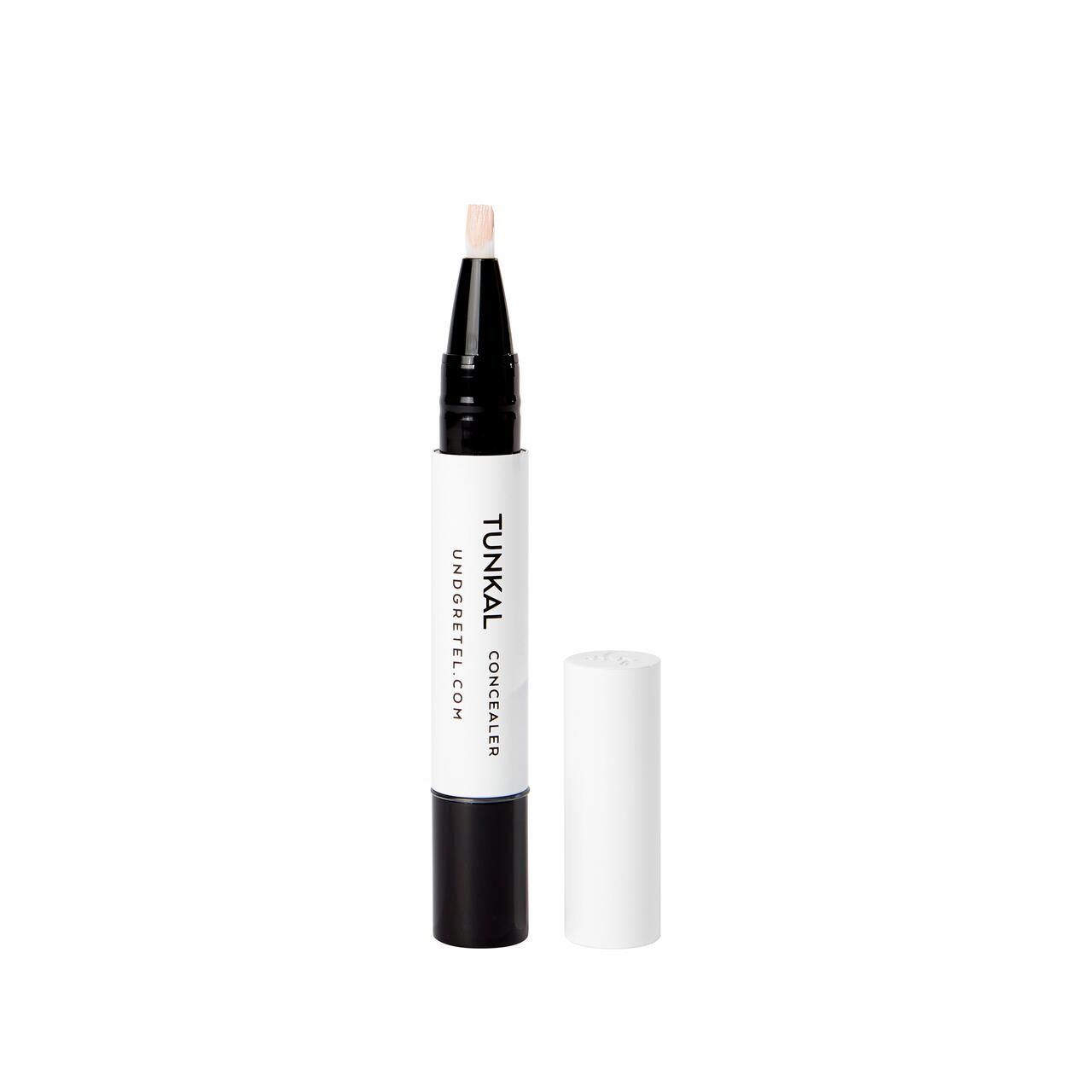 Concealer-Stift mit geöffneter Kappe. Weißer Stift mit schwarzem Ende. Aufschrift: Tunkal Concealer, undgretel.com. Spitze mit Concealer.