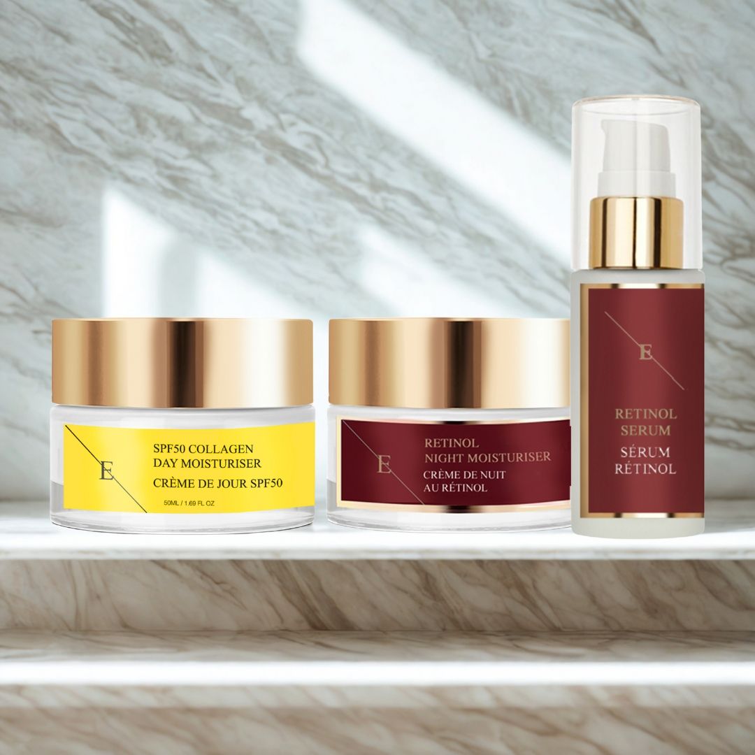 Drei Kosmetikprodukte: Tagescreme, Nachtcreme und Serum. Goldfarbene Deckel, Etiketten mit Text. Aufschrift: Retinol Serum, SPF50 Collagen Day Moisturiser.