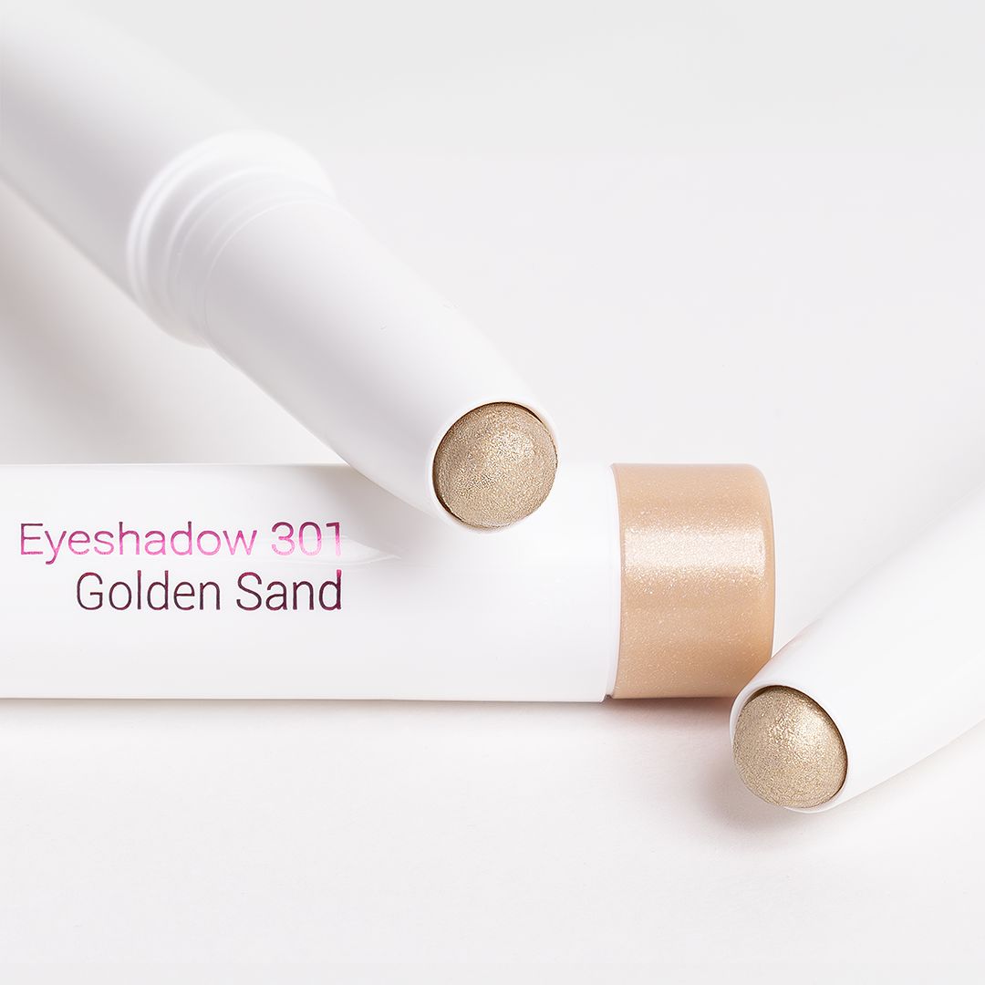 Zwei weiße Lidschattenstifte mit goldfarbenen Spitzen. Text: Eyeshadow 301 Golden Sand.
