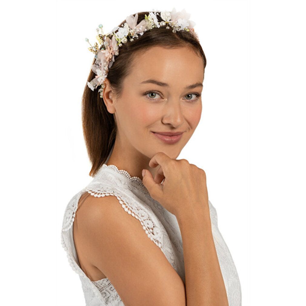 Blumenstirnband mit Blüten und Blättern. Die Frau trägt ein Kleid mit floralem Muster. Nahaufnahme, vor weißem Hintergrund.