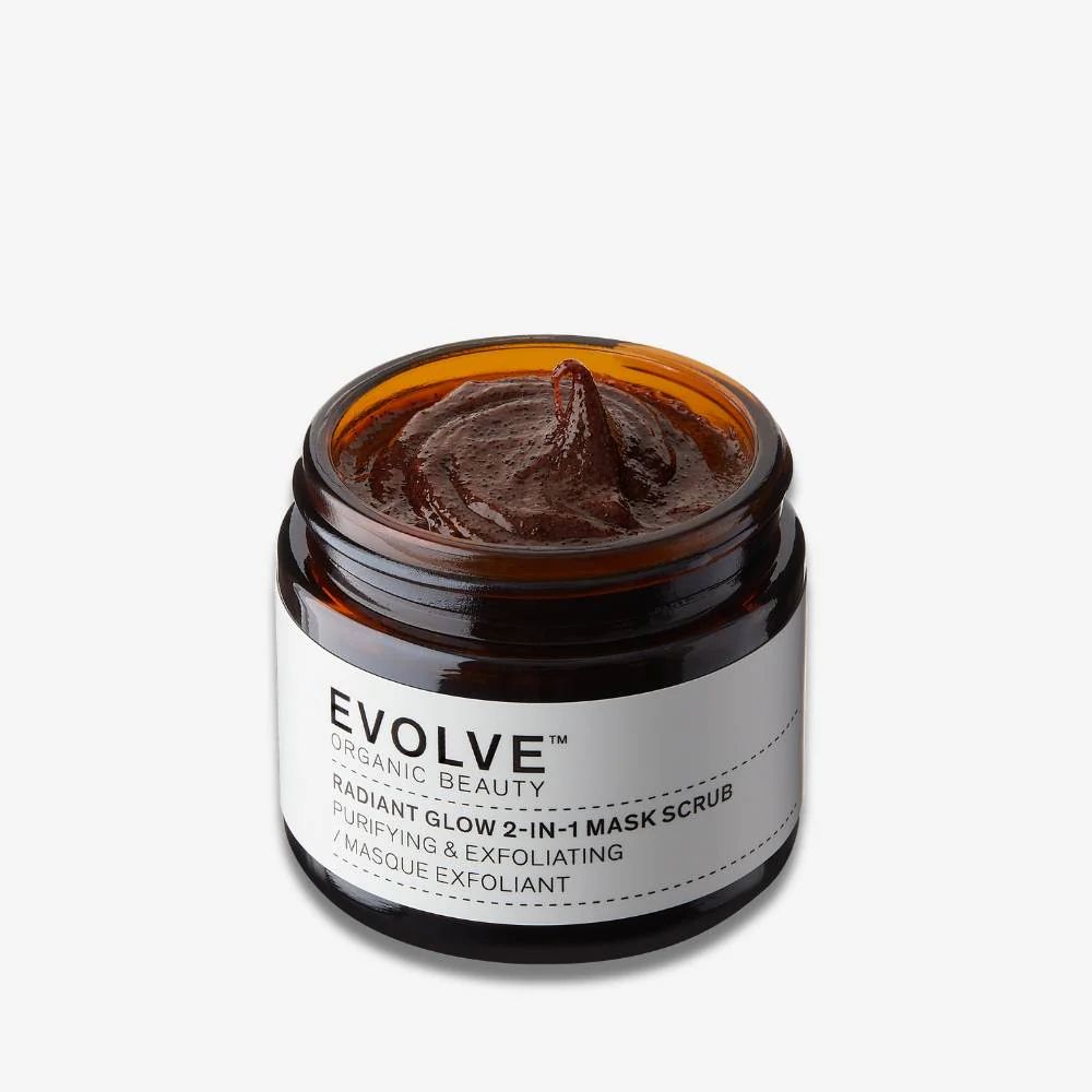 Braune Maske in einem braunen Glasbehälter. Auf dem Etikett steht: EVOLVE ORGANIC BEAUTY, RADIANT GLOW 2-IN-1 MASK SCRUB.