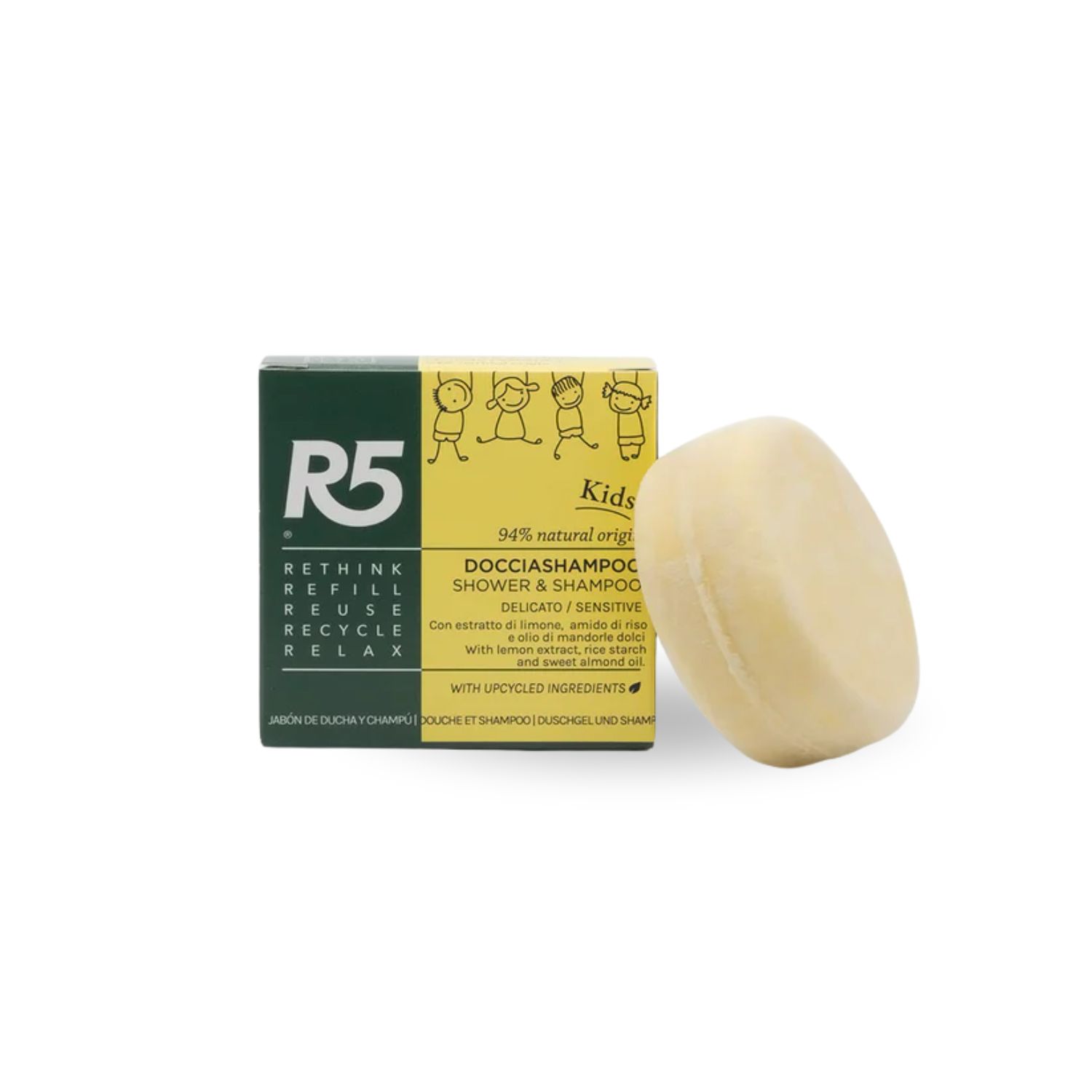 Runder, cremefarbener Duschshampoo-Festkörper neben Verpackung. Text: R5, Kids, Docciaschampoo.