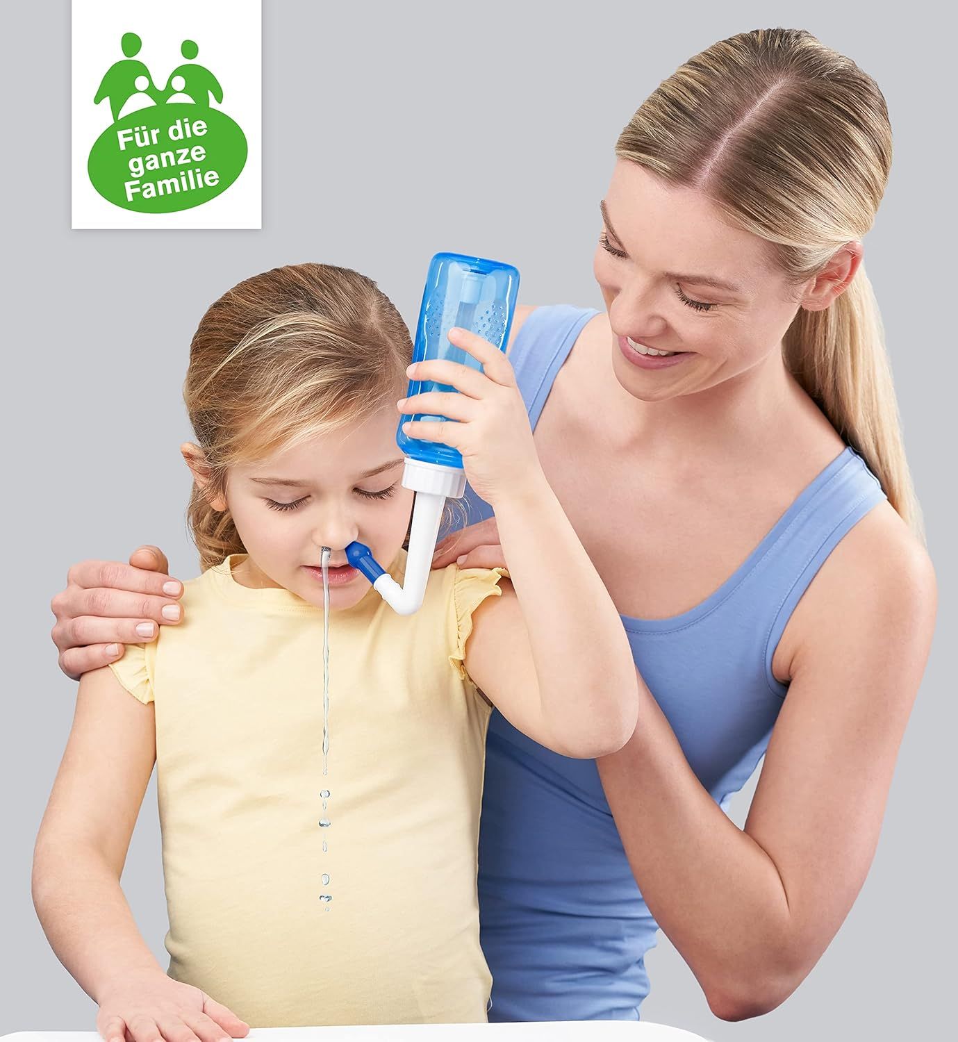 Frau und Kind. Kind erhält Nasendusche. Blaue Nasendusche. Logo: Für die ganze Familie.
