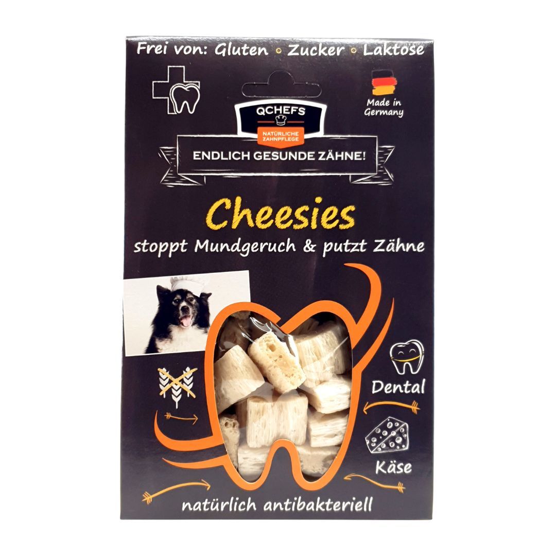 Verpackung von QCHEFS Cheesies. Schwarzer Karton mit Produktabbildung und Text. Frei von Gluten, Zucker, Laktose. Made in Germany.