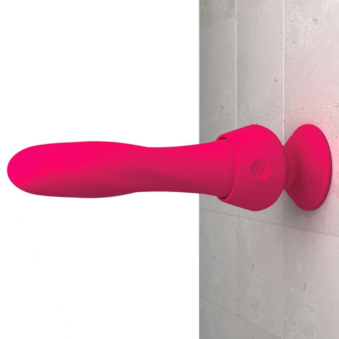 Rosa Vibrator an einer Wand befestigt. Saugnapf-Halterung. Auf grauem Hintergrund.