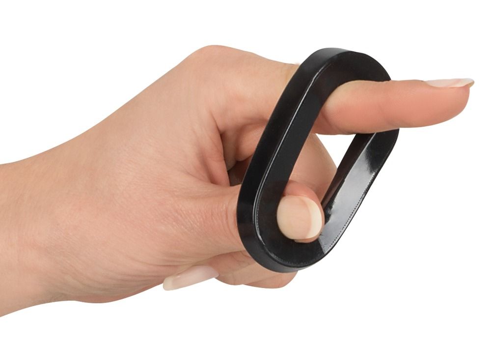 Hand mit einem schwarzen, rechteckigen Ring um einen Finger.