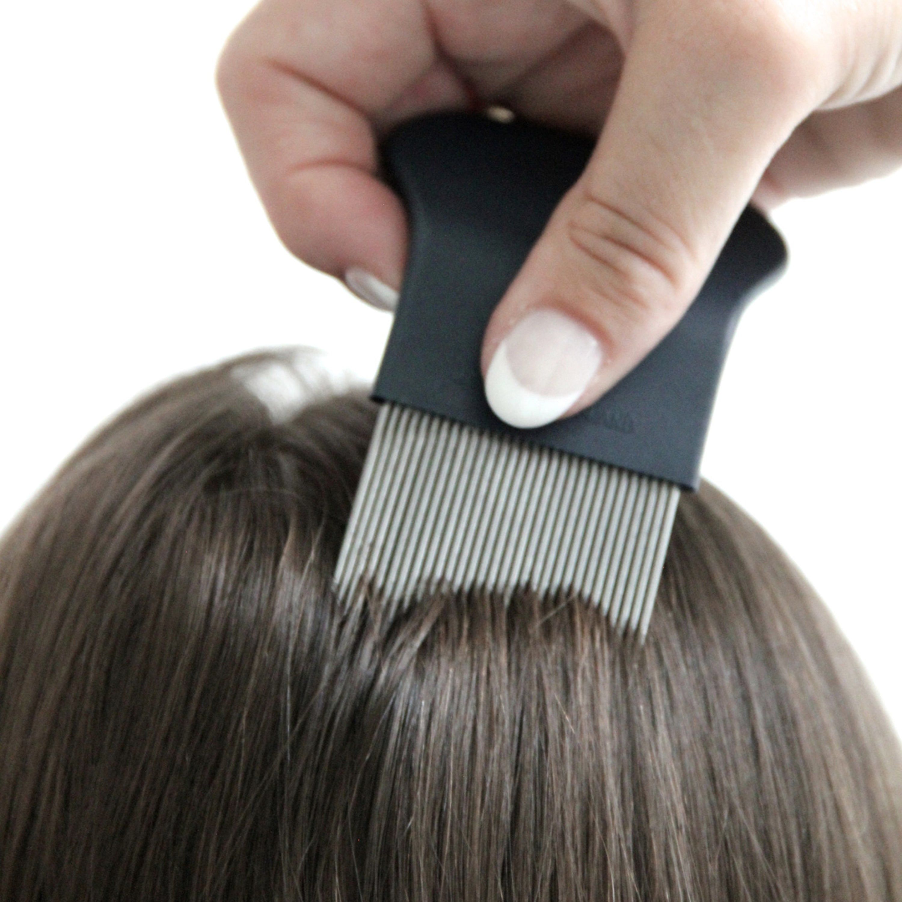 Hand kämmt Haare mit einem schwarzen Läusekamm. Feine Zähne.