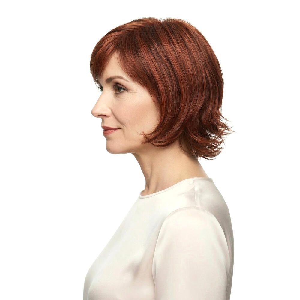 Frau mit roter Perücke MAILAND. Profilansicht. Kurzes, gewelltes Haar. Trägt ein cremefarbenes Oberteil.