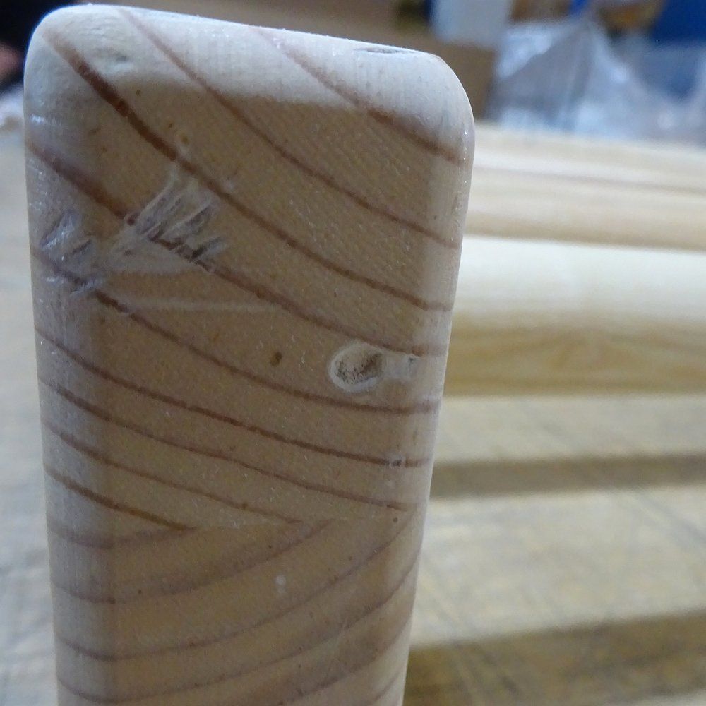 Detailansicht einer Holz-Kletterwand mit sichtbarer Maserung und Markierung.