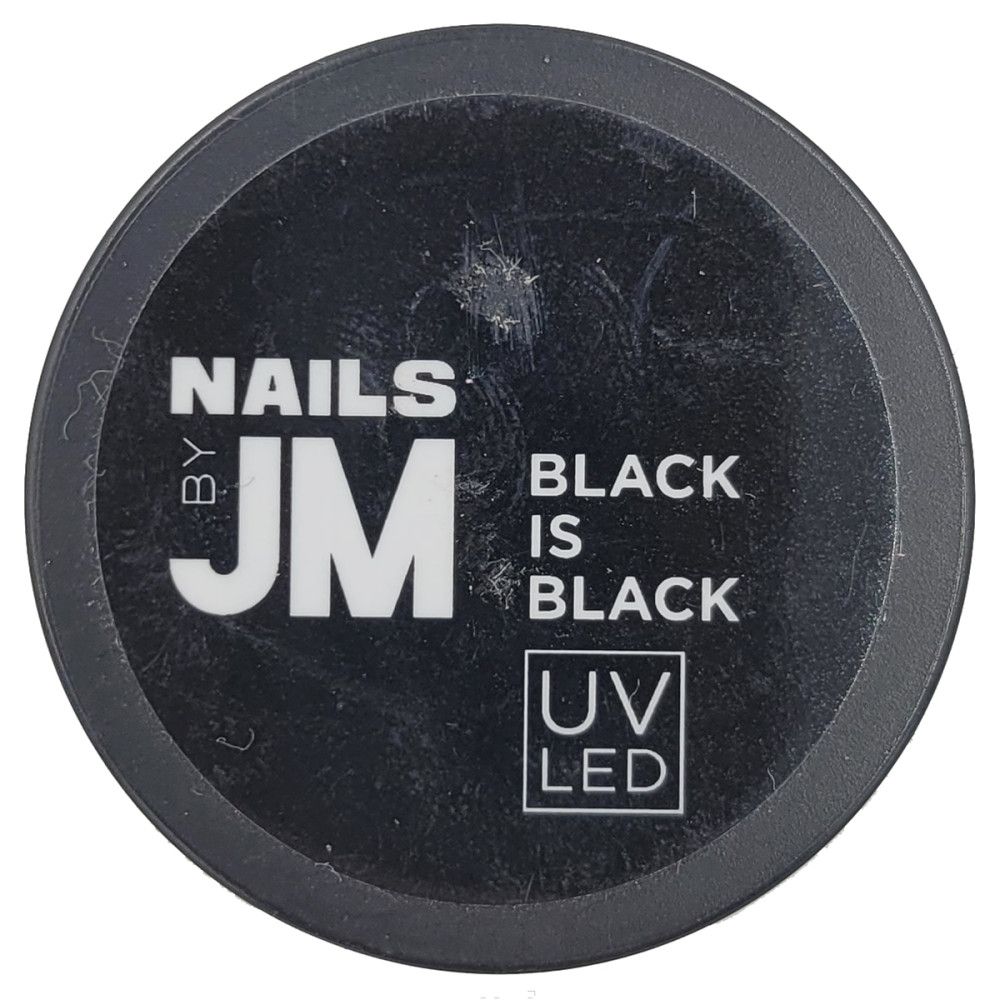 Runder, schwarzer Behälter. Aufschrift: NAILS BY JM, BLACK IS BLACK, UV LED.