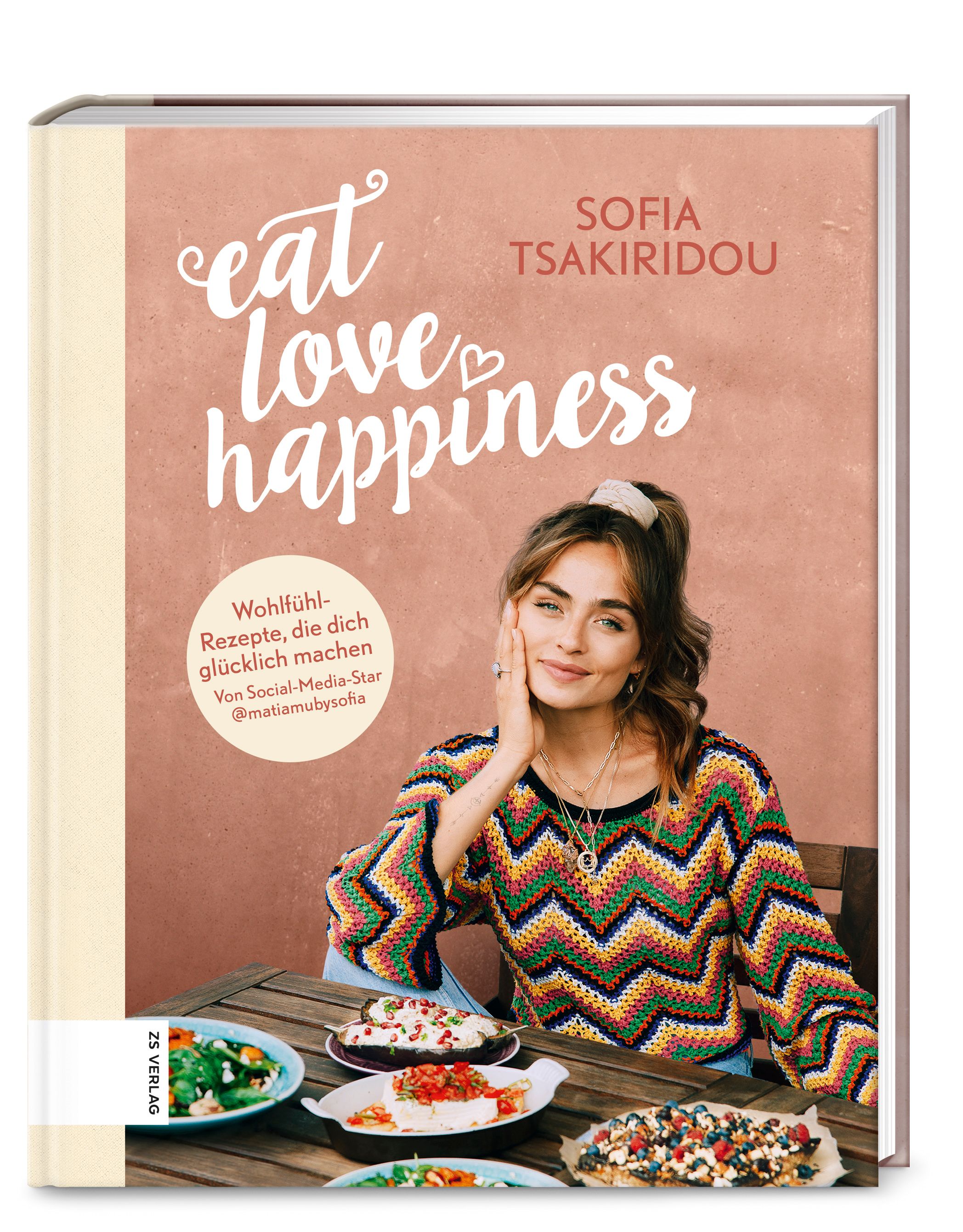 Buchcover von "Eat Love Happiness". Titel in weißer Schrift, Autorin Sofia Tsakiridou. Frau am Tisch, Essen. Verlag Logo.