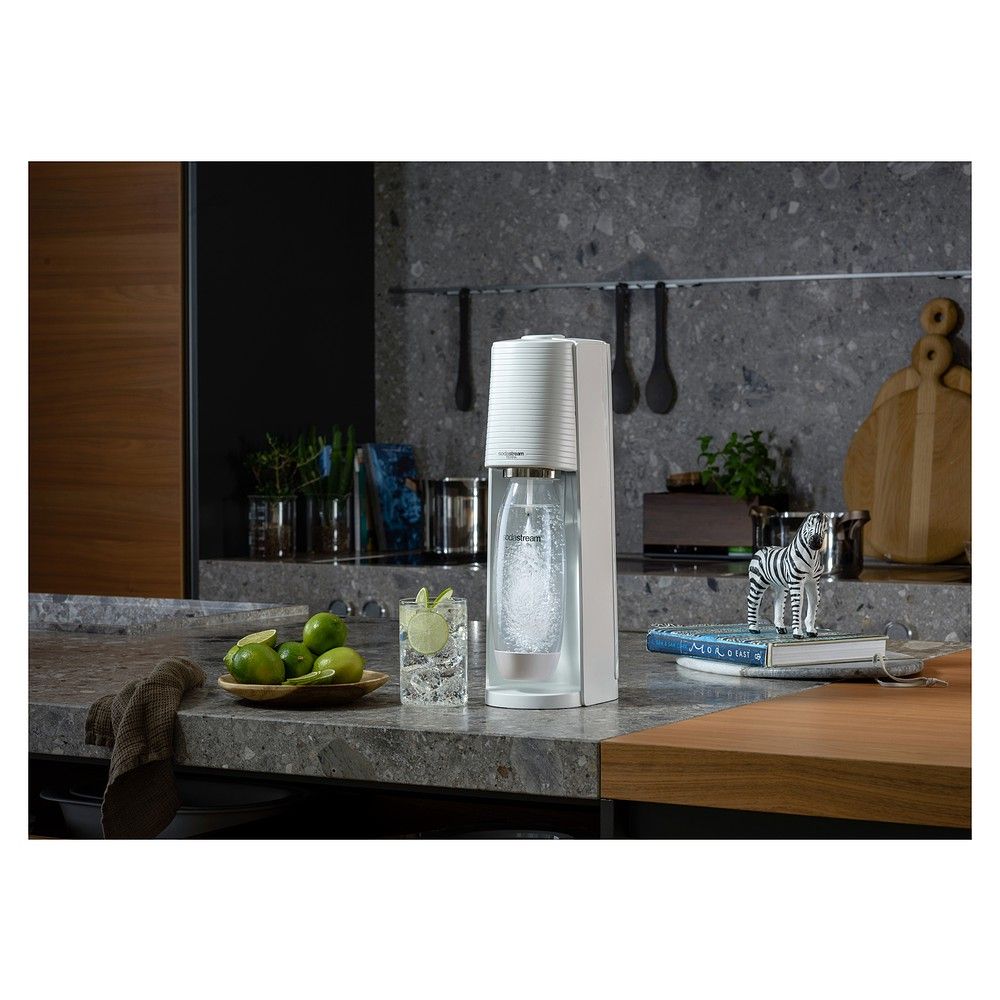 SodaStream Terra weiß Wassersprudler in einer Küche mit Zitrone und Glas Wasser.