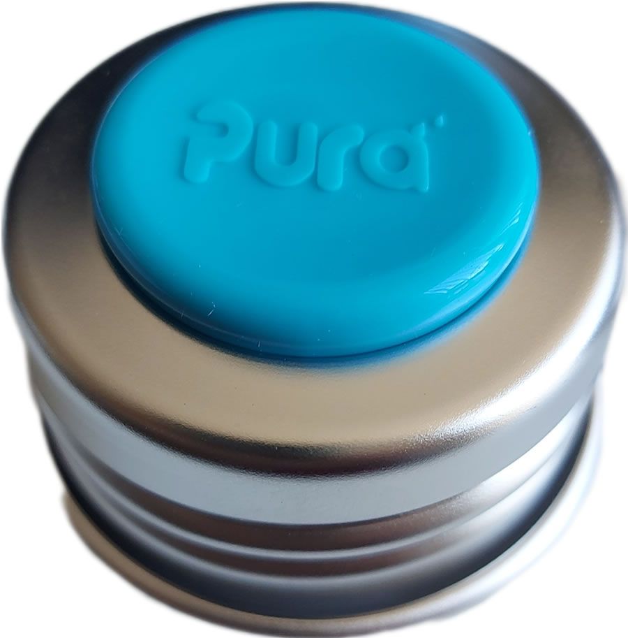 Deckel mit blauem Knopf. Auf dem Knopf steht "Pura". Der Deckel ist aus Metall.
