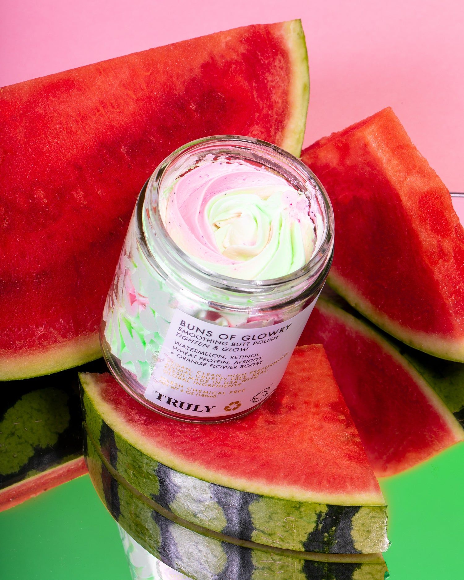 Glasbehälter mit rosa, grünem und weißem Produkt. Umgeben von Wassermelonenstücken. Aufschrift: Buns of Glowry.