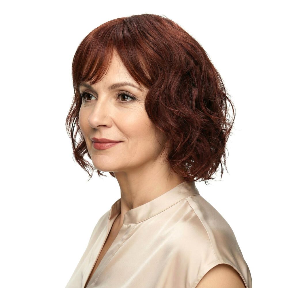 Rote Perücke mit gewelltem Haar und Pony. Seitenansicht einer Frau mit hellem Oberteil.