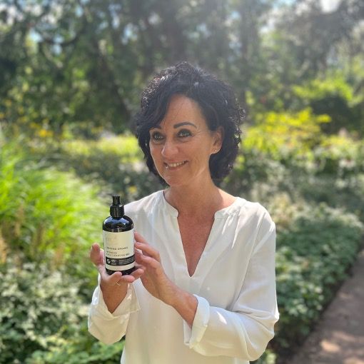 Eine Frau hält eine Flasche Reinigungsgel. Text: Intensive Face Cleansing Gel, Vegan, IFC, Cosmos Organic.