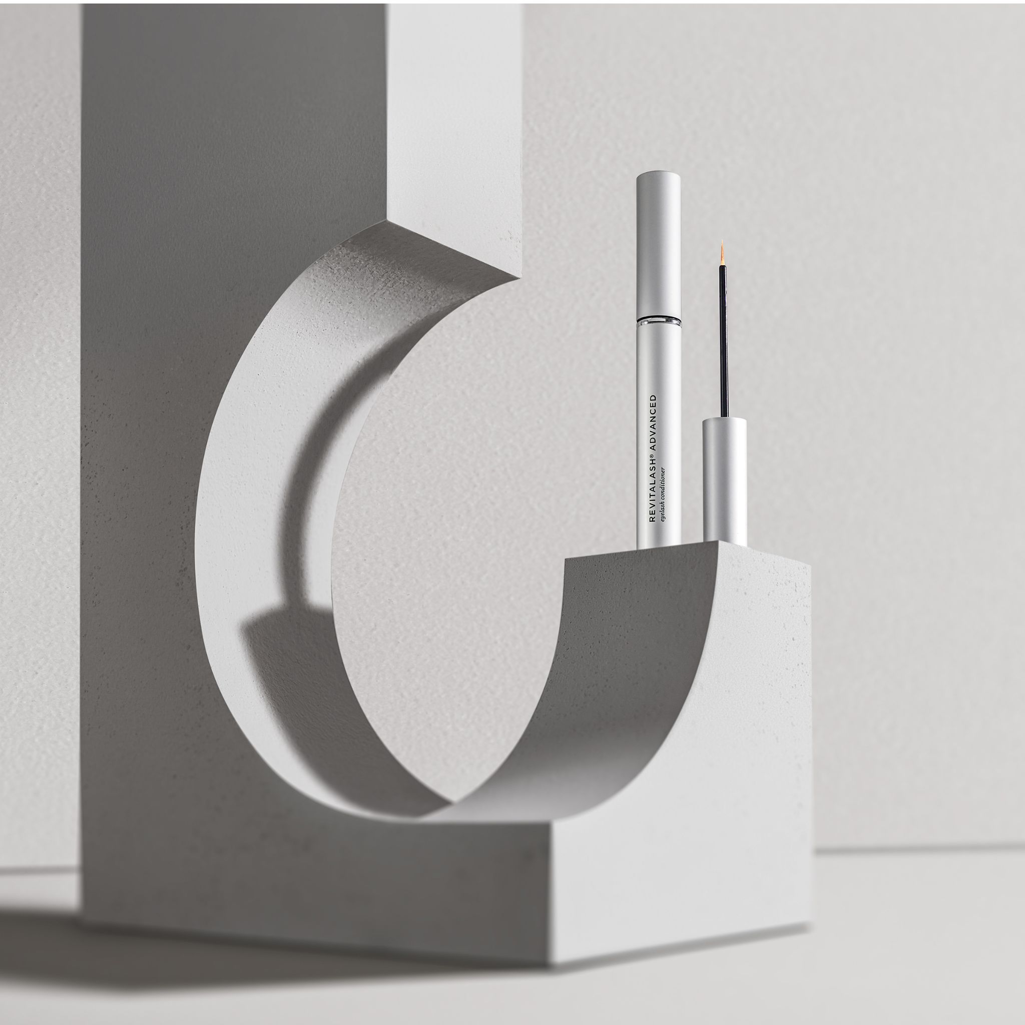 RevitaLash® Advanced Eyelash Conditioner auf modernem Ständer.