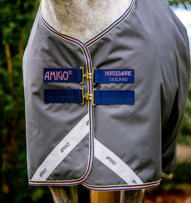 Nahaufnahme der Pferdedecke mit Logo-Aufnähern. Markenname 'AMIGO' und 'Horseware Ireland'.