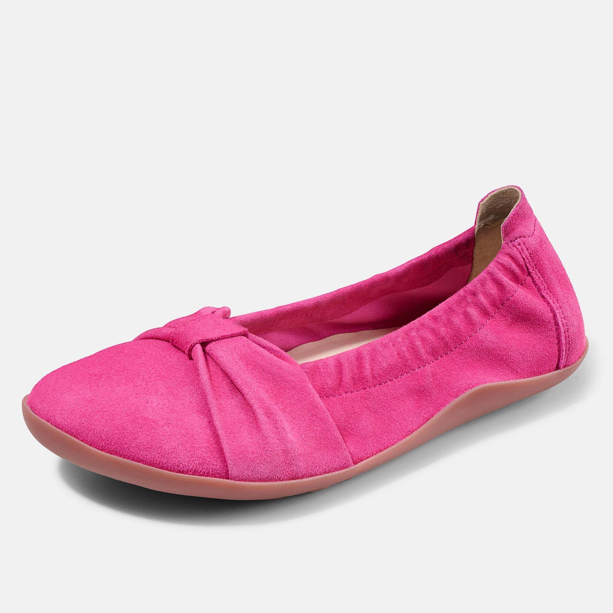 Eine pinke Ballerina aus Wildleder mit Schleifen-Detail und Gummizug, von vorne.