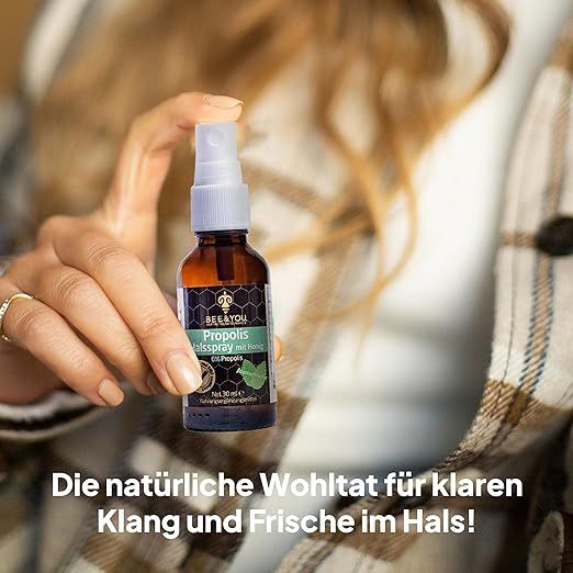 Person hält Sprühflasche in der Hand. Aufschrift auf der Flasche: Propolis Halsspray. Text: Die natürliche Wohltat für klaren Klang und Frische.