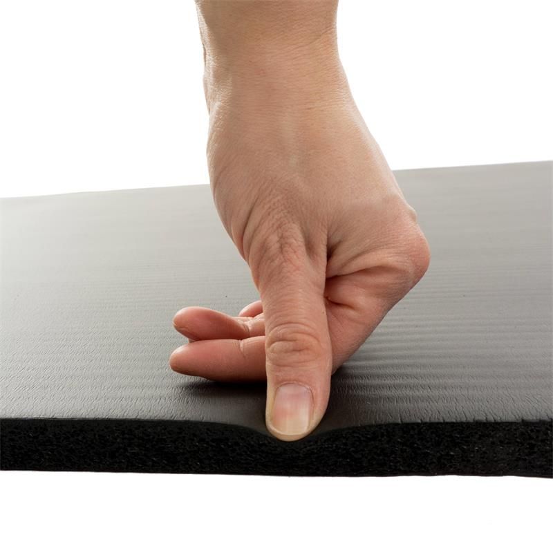 Hand drückt auf schwarze Gymnastikmatte. Material wird zusammengedrückt.
