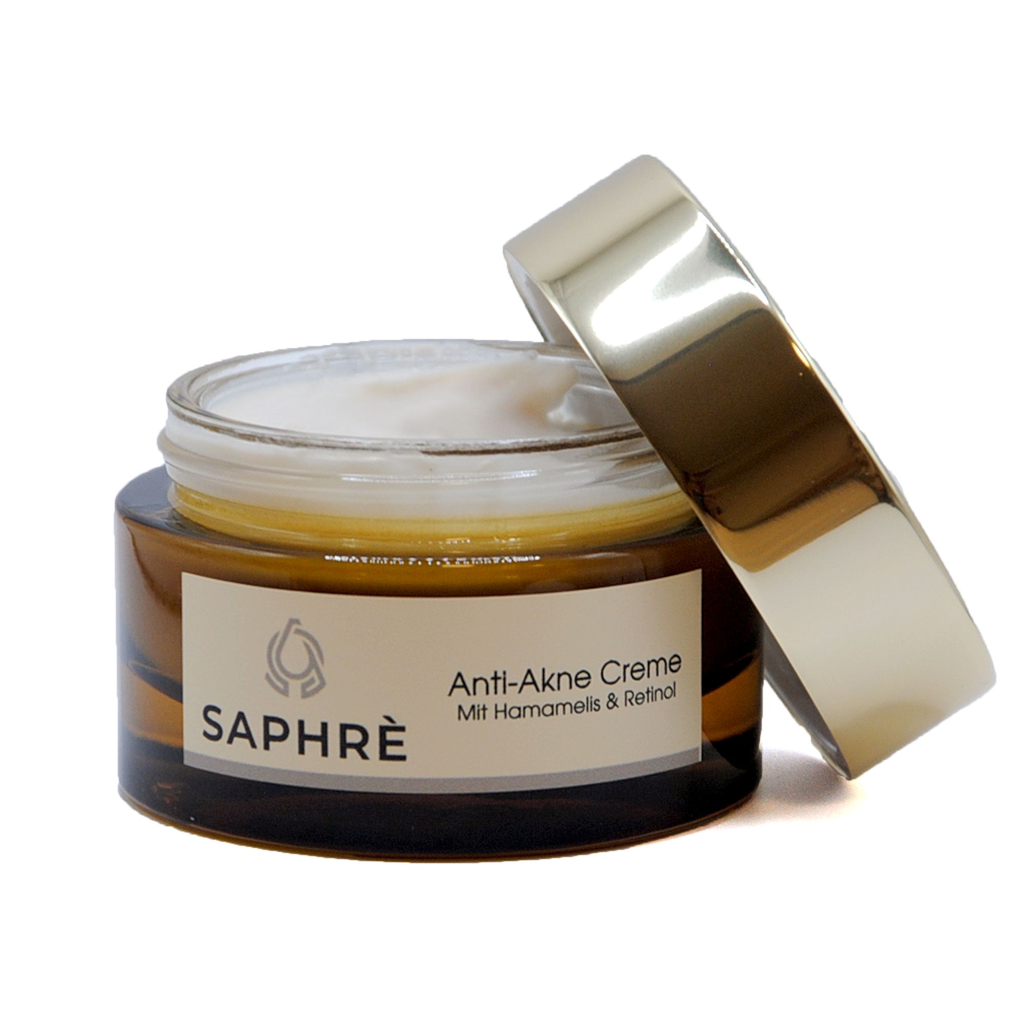 Braunes Glas mit geöffnetem goldfarbenem Deckel. Creme sichtbar. Etikett "SAPHRE".
