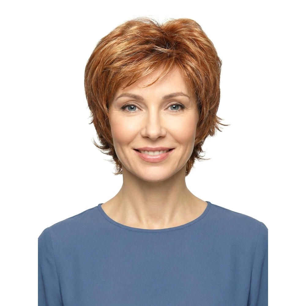 Frau mit rotbrauner Perücke mit kurzem, gewelltem Haar. Sie trägt ein blaues Oberteil und lächelt.
