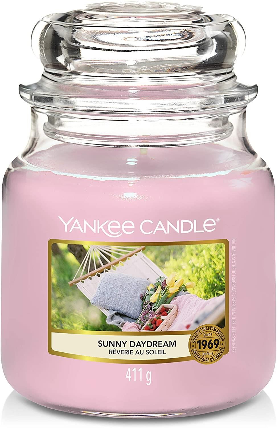 Yankee Candle Duftkerze Sunny Daydream. Rosa Kerze im Glasbehälter mit Deckel. Etikett mit Bild einer Hängematte. Gewicht: 411 g.