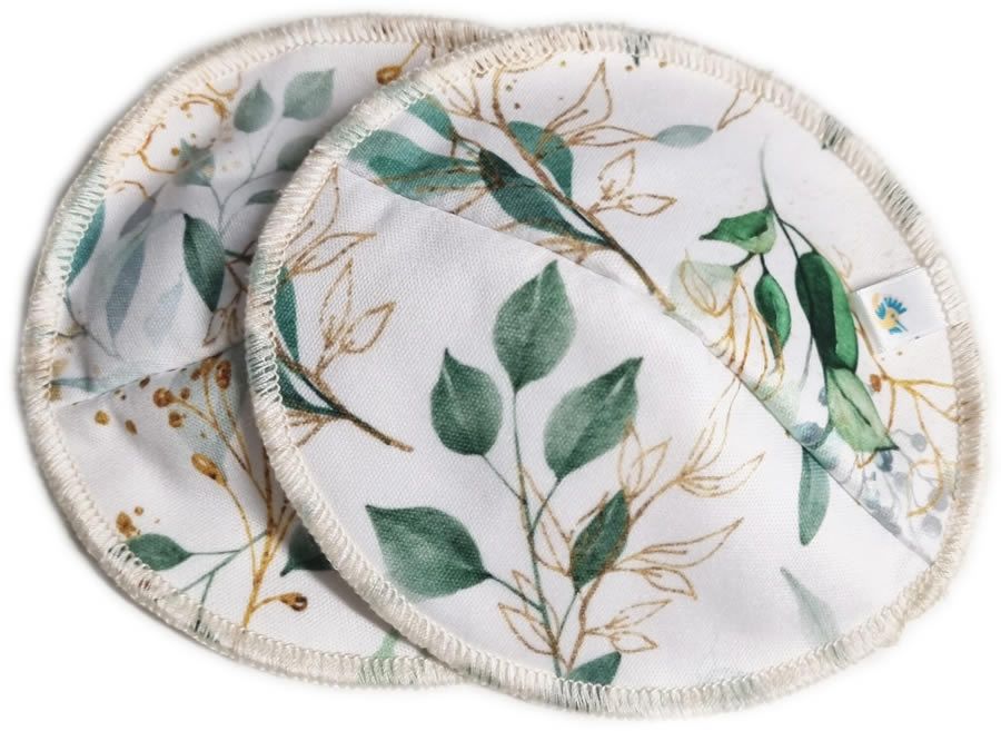 Zwei runde Stilleinlagen mit Blättermuster in Grün und Gold auf weißem Grund. Mit cremefarbenem Rand.