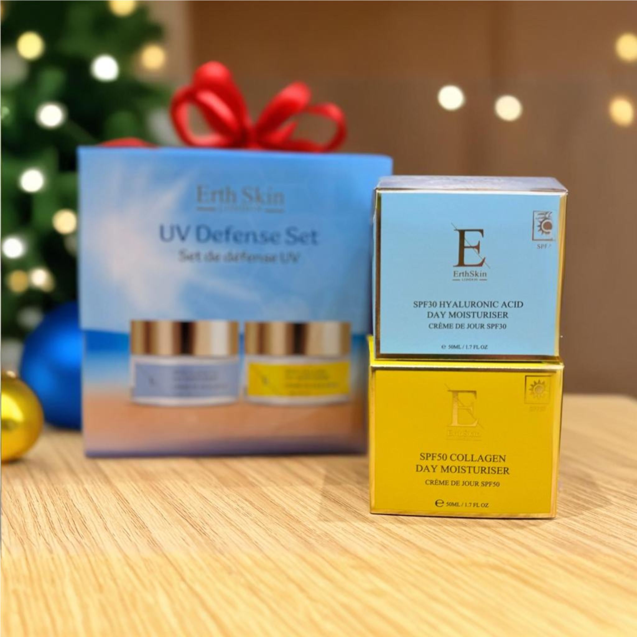 Geschenkset mit zwei Cremes und zwei Schachteln. Auf der Verpackung steht "Erth Skin UV Defense Set". Die Cremes haben goldene Deckel und Etiketten.