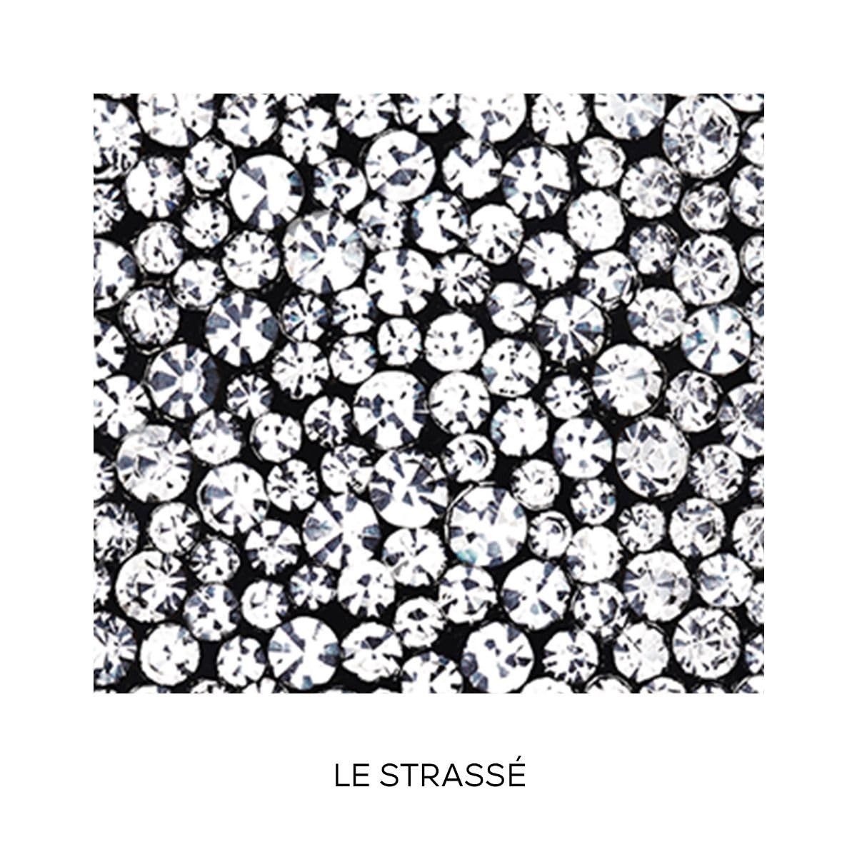 Nahaufnahme von Strasssteinen auf schwarzem Hintergrund. Text: LE STRASSÉ.