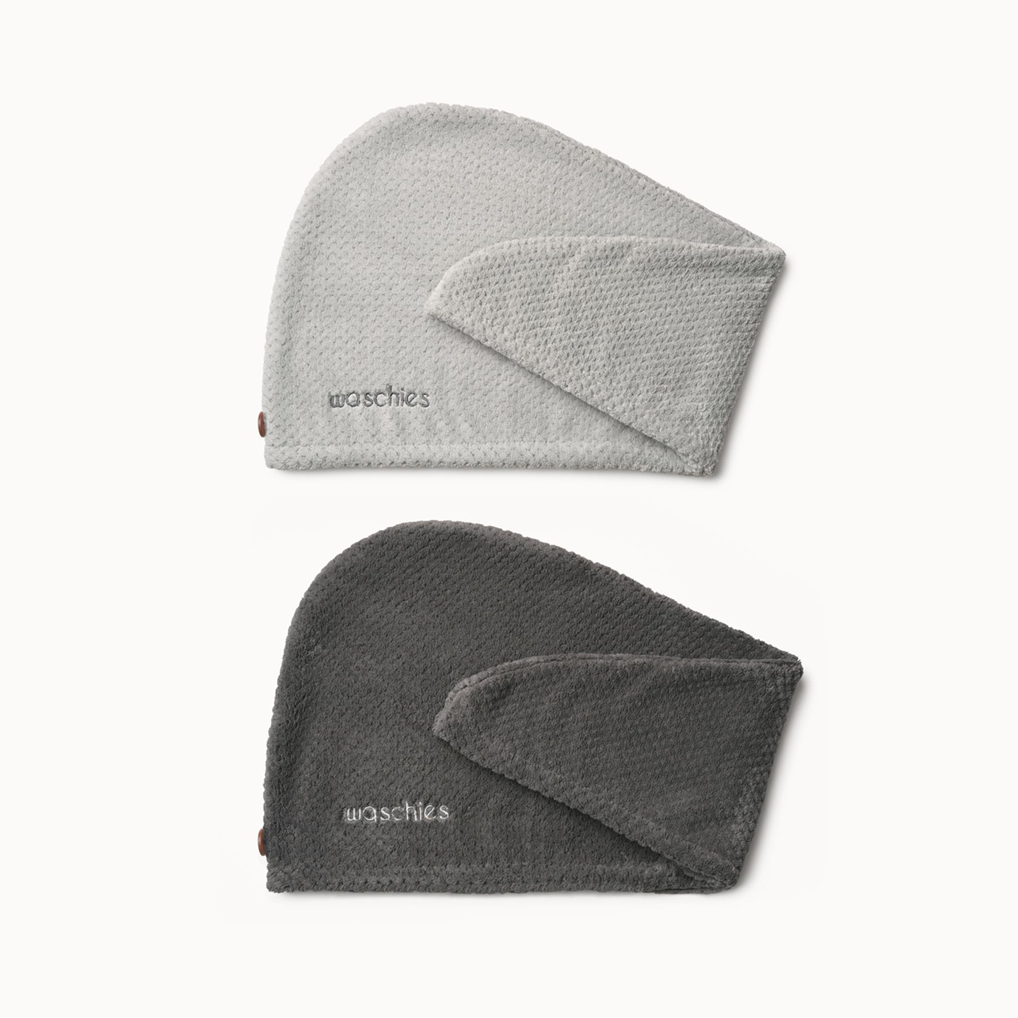 Zwei Mikrofaser-Haarturbane in Grau und Anthrazit. Beide haben das Logo "waschies".
