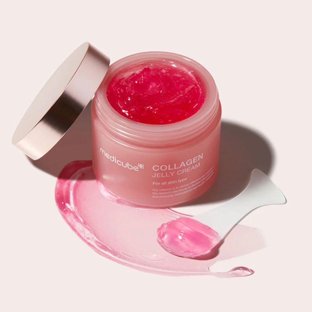 Geöffnete Dose Medicube Collagen Jelly Cream mit rosa Gel und Spatel. Aufschrift: Collagen Jelly Cream. Deckel daneben.