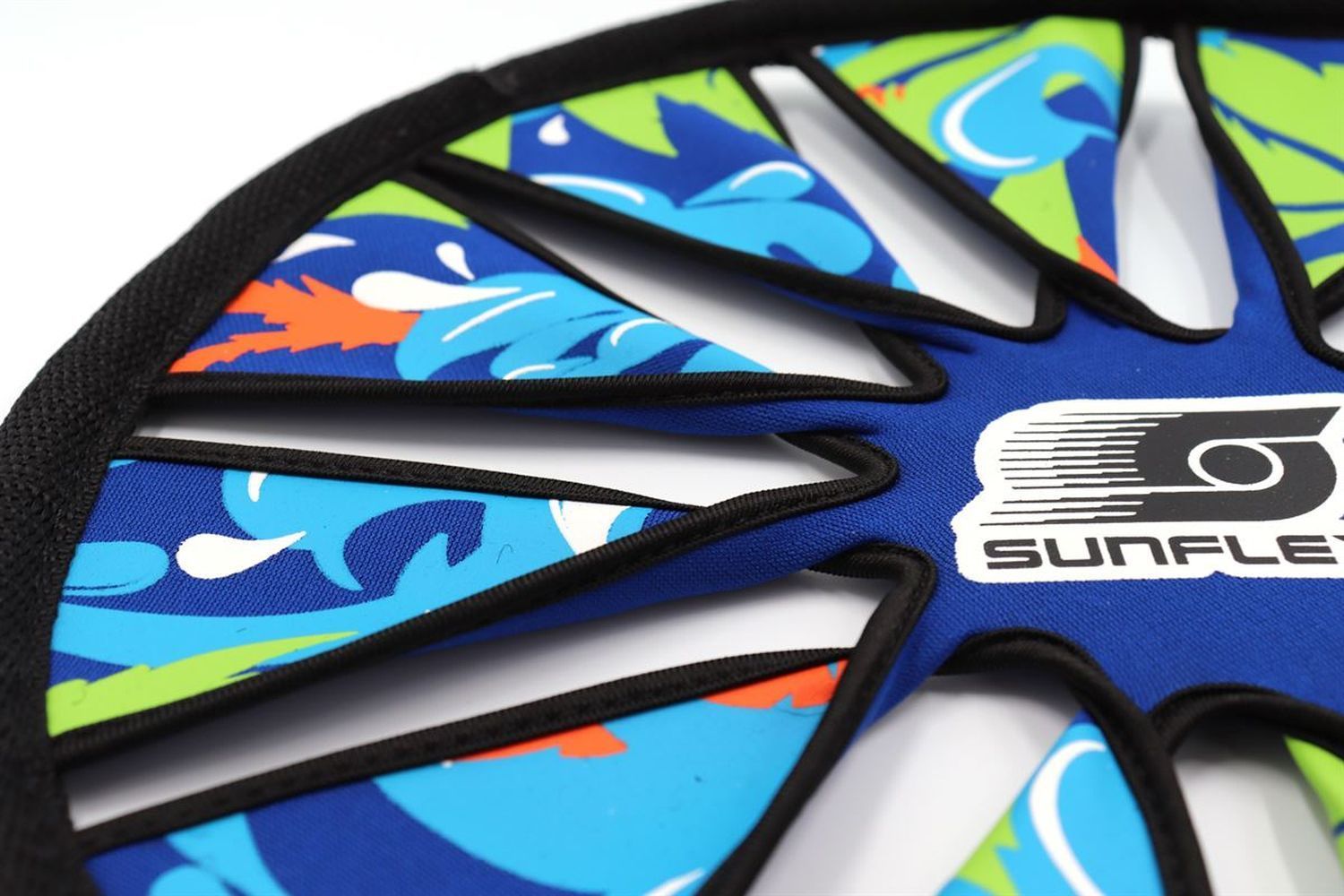 Nahaufnahme eines blauen Frisbees mit floralem Muster. Schwarzer Rand und weiße Speichen.