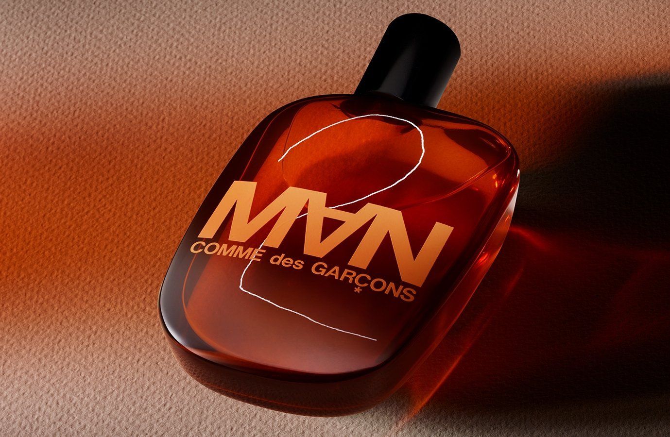 CDG 2 MAN Eau de Toilette Spray. Braune Flüssigkeit im Flakon. Schwarzer Verschluss. Logo und Schriftzug.