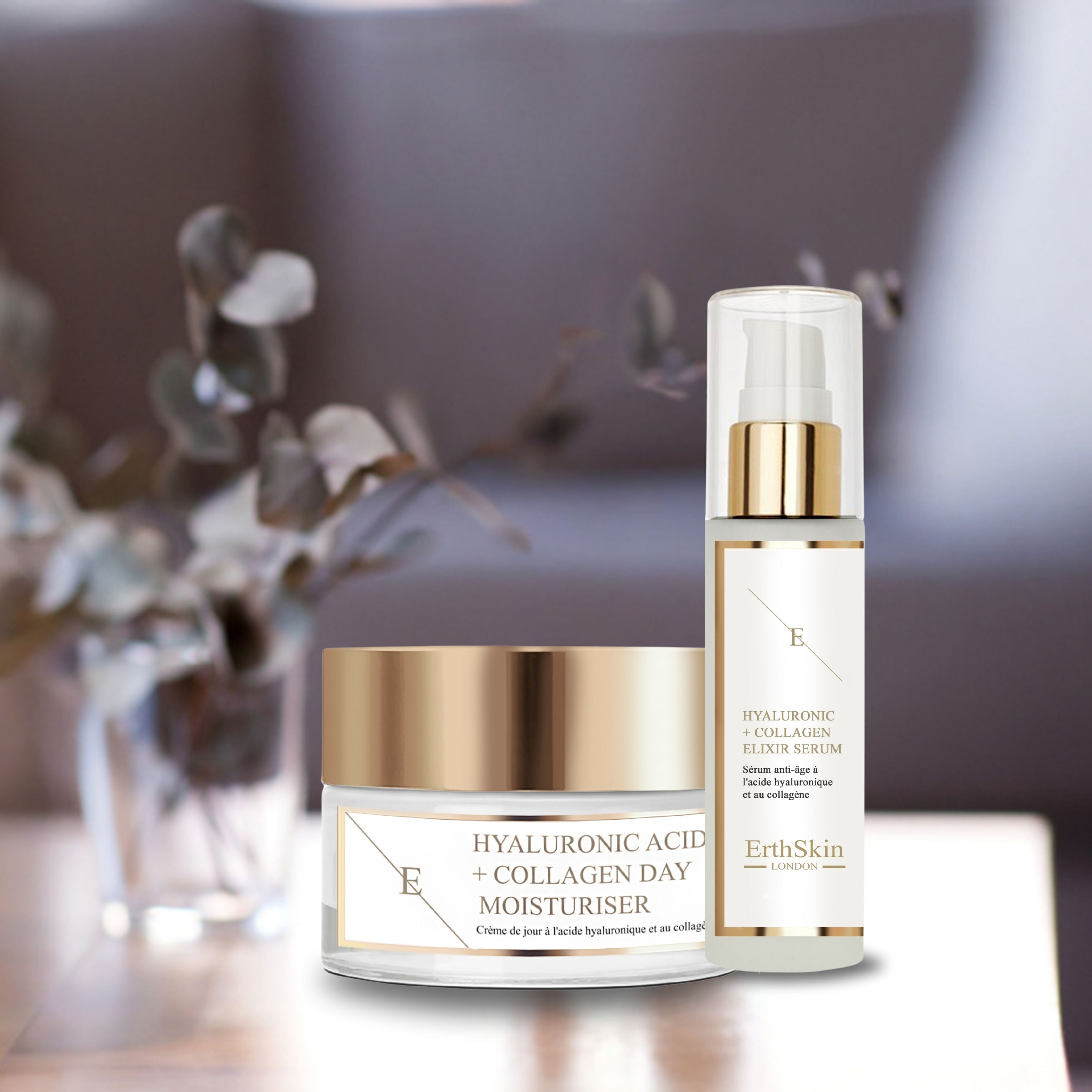 Tagescreme und Serum-Set. Creme-Tiegel und Serum-Flasche mit goldfarbenen Deckeln. Aufschrift: Hyaluronsäure + Collagen. Auf einem Tisch.
