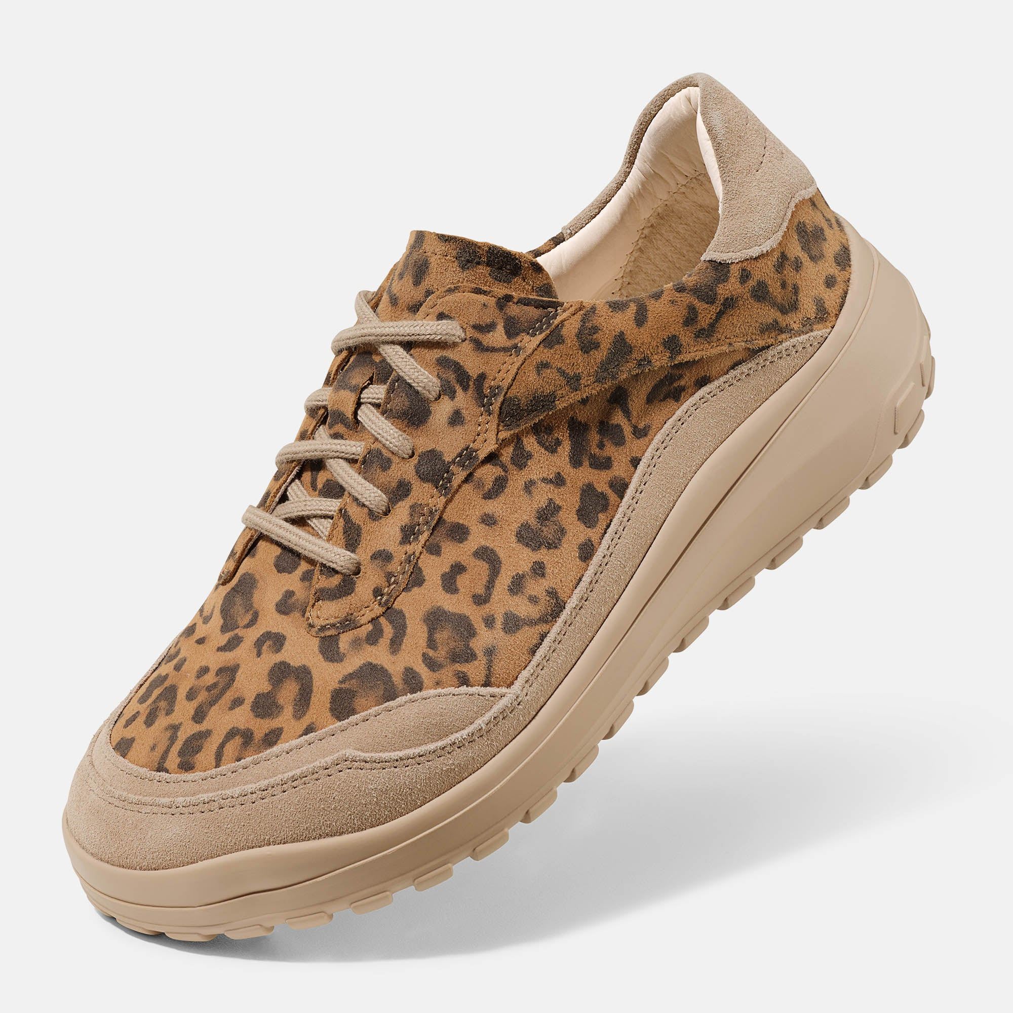Brauner Schnürschuh mit Leopardenmuster. Breite Form. Beige Sohle und Schnürsenkel. Wildleder-Details. Schrägansicht.