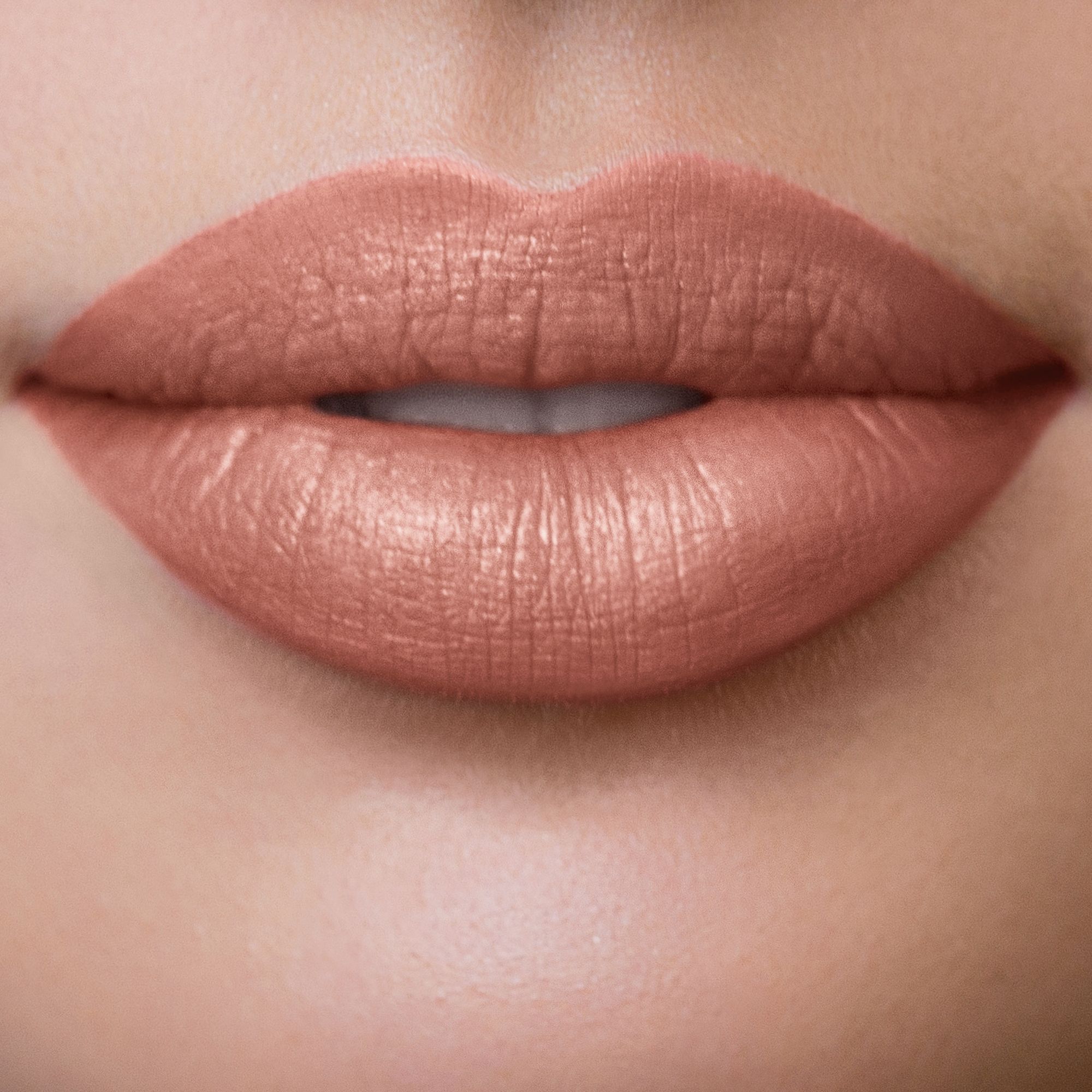 Nahaufnahme von Lippen mit nude-farbenem Lippenstift.