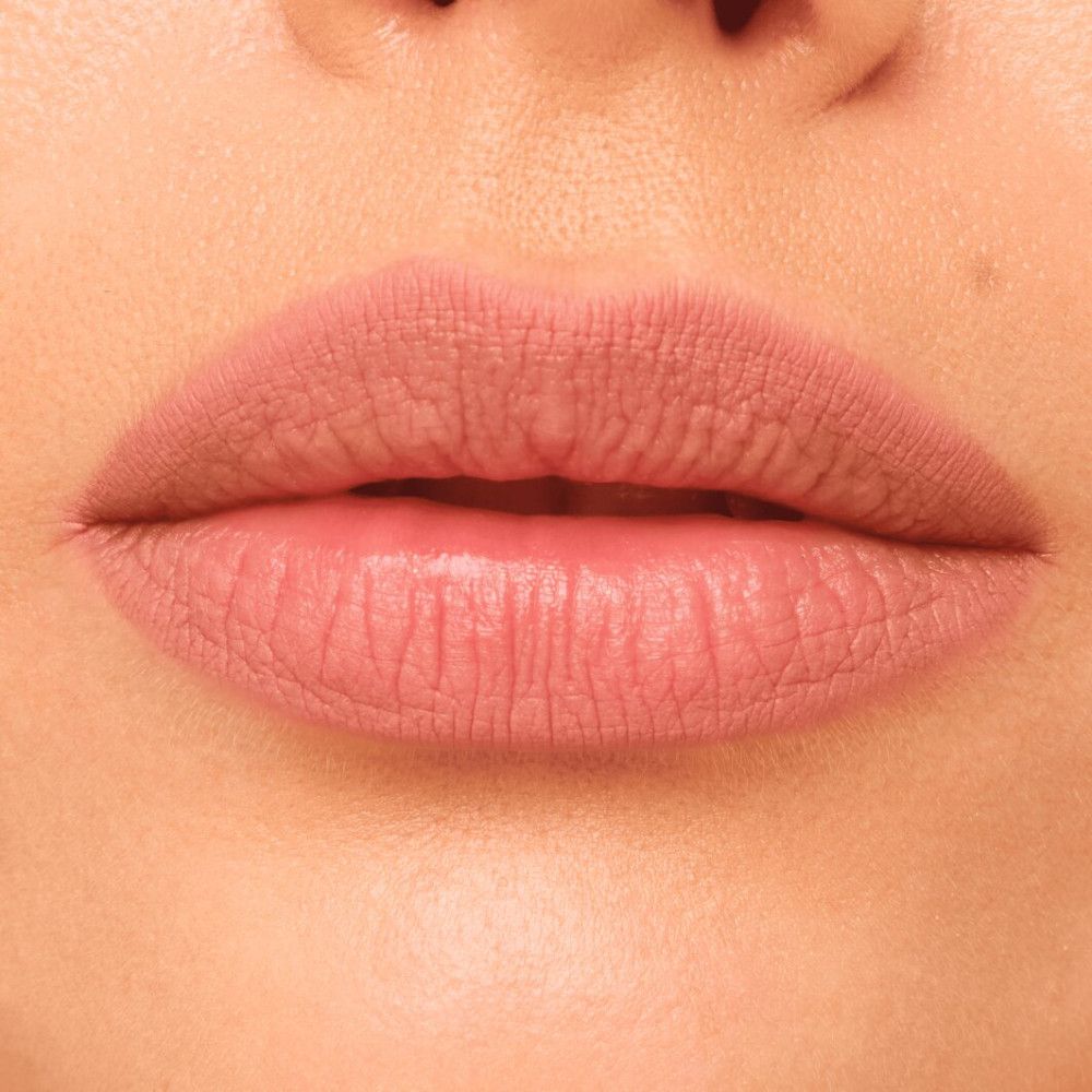 Nahaufnahme von Lippen, die mit einem rosa Lippenkonturenstift umrandet sind. Die Lippen sind leicht geschminkt.