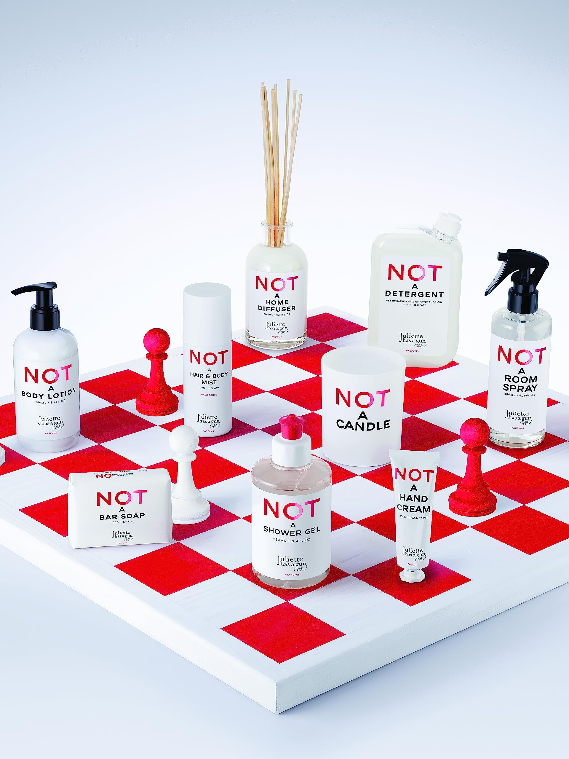Produktreihe auf Schachbrett. NOT-Produkte: Bodylotion, Haar- & Körperspray, Diffusor, Waschmittel, Raumspray, Seife, Duschgel, Handcreme.