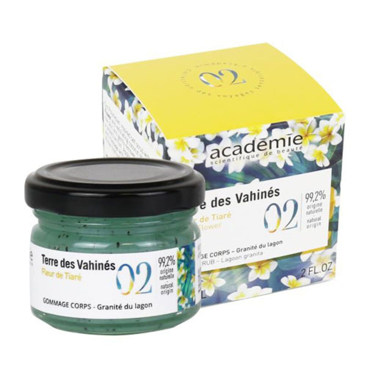 Glas mit grünem Körperpeeling und schwarzem Deckel. Dahinter eine gelbe Schachtel mit floralem Muster und Produktinformationen.