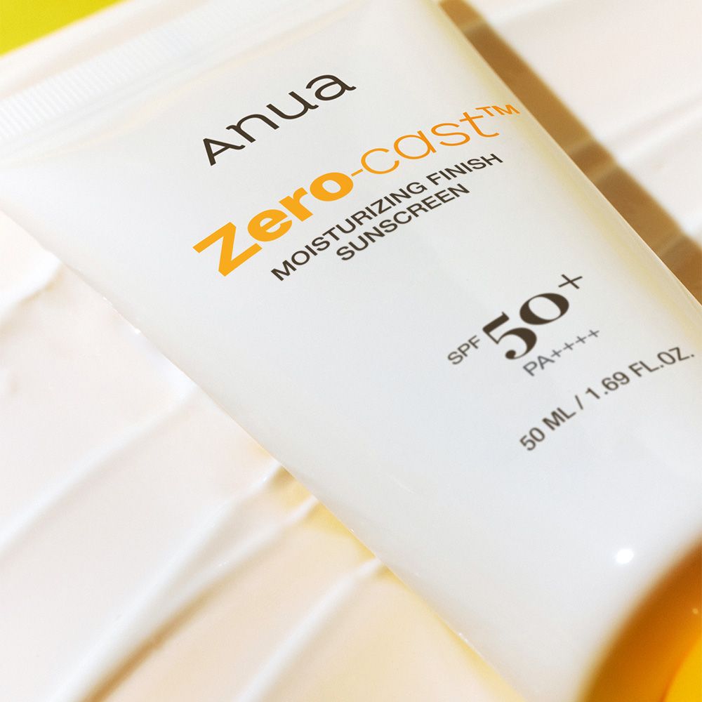 Nahaufnahme einer Anua Zero-Cast Sonnenschutzmittel-Tube, SPF 50, auf einer cremigen Textur.