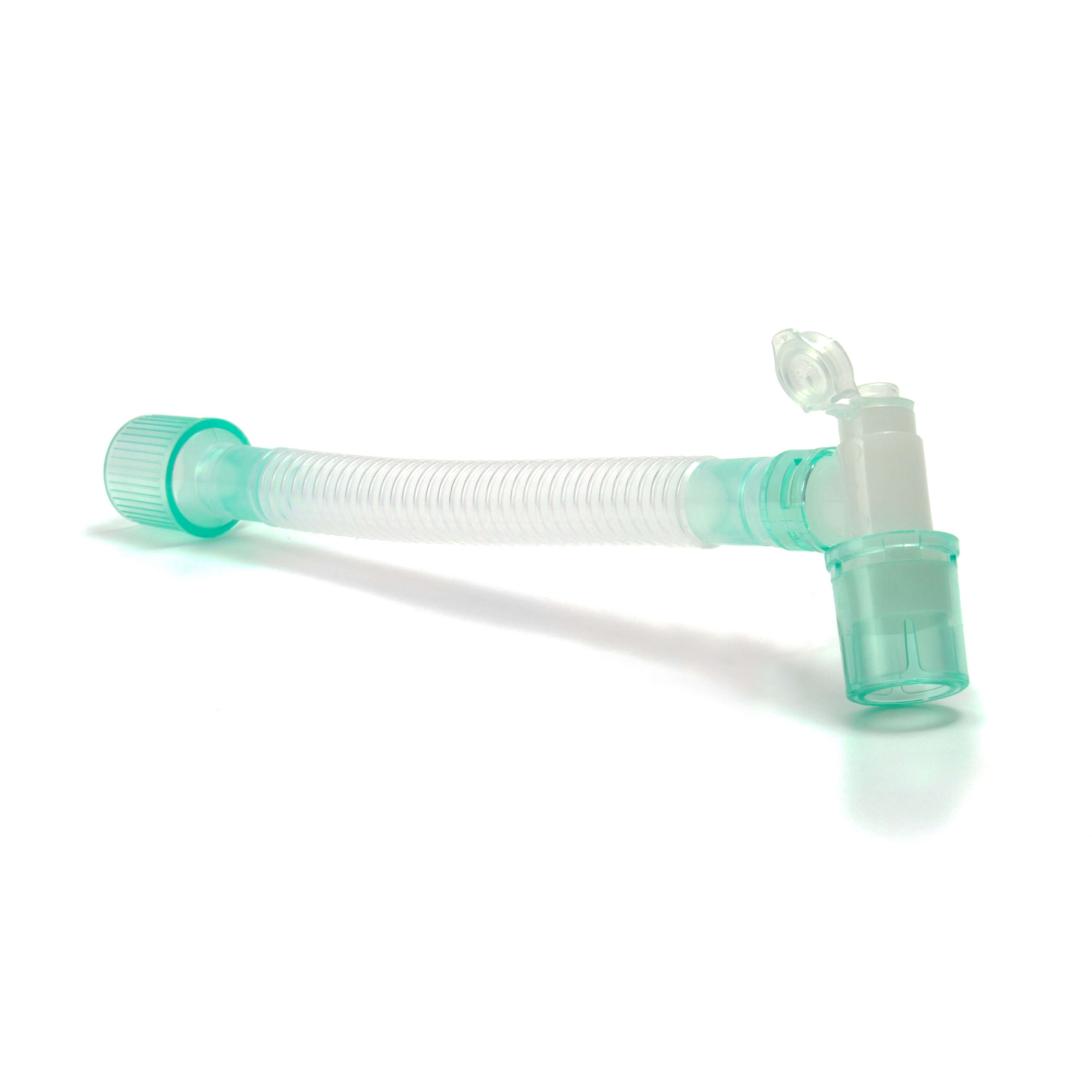 Medizinischer Konnektor mit gewelltem Schlauch, grünlichen Anschlüssen und Klappverschluss. Auf weißem Hintergrund.