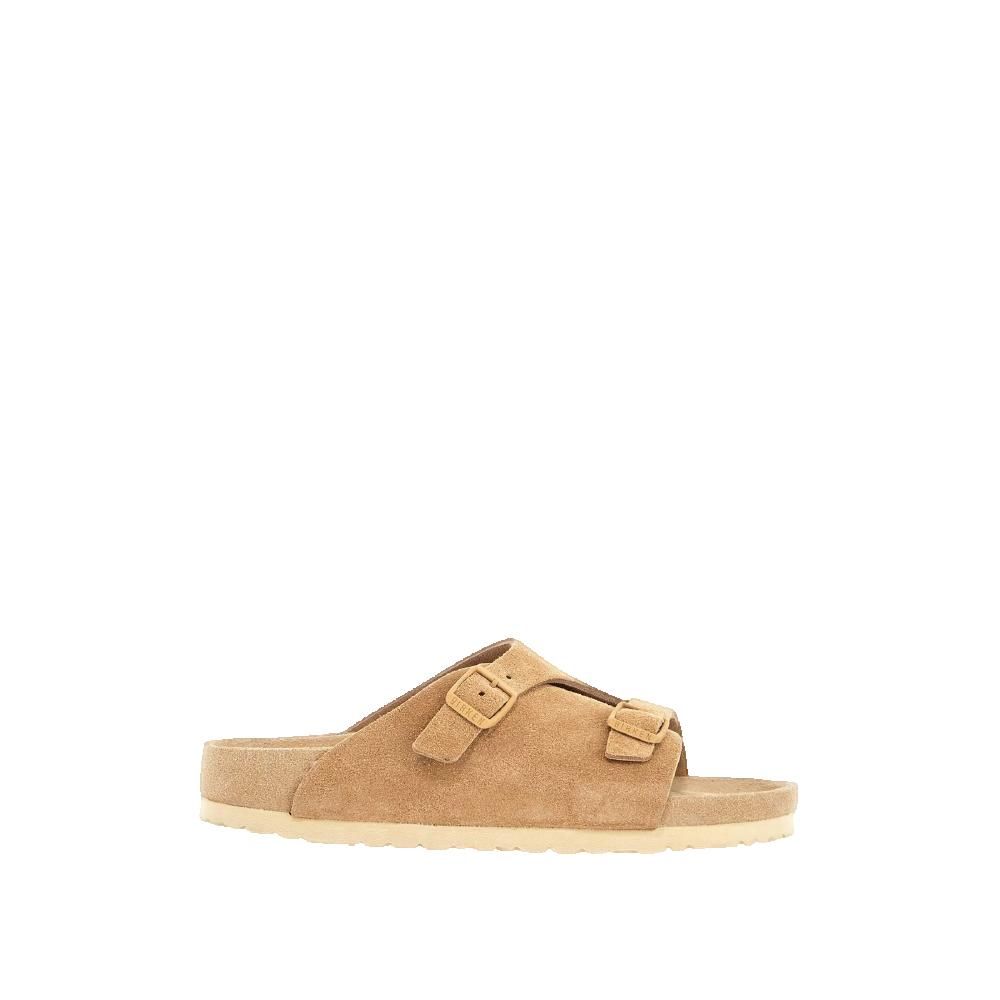 Sandalo con due cinturini e fibbie. Camoscio beige, suola chiara. Marchio sulla fibbia.