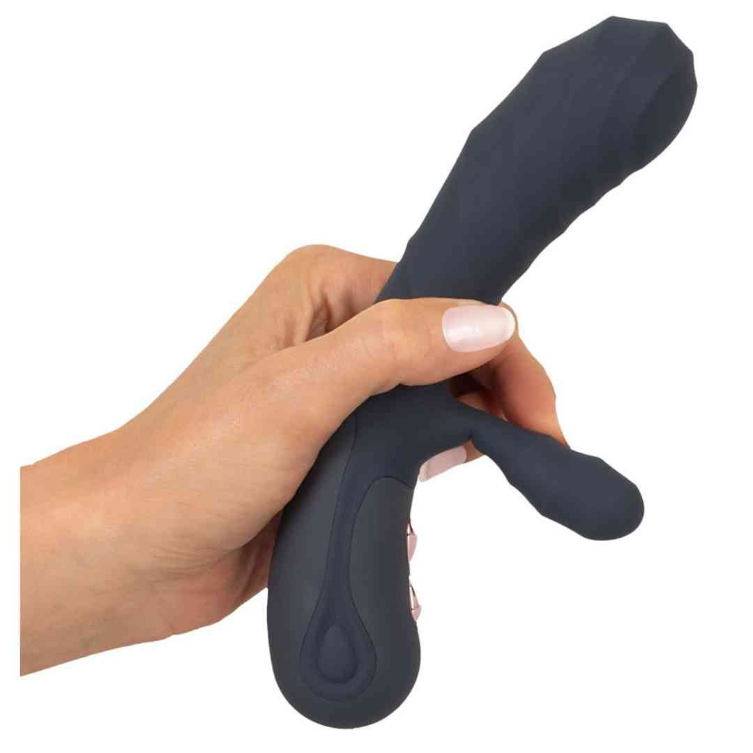 Dunkelgrauer Vibrator in einer Hand gehalten. Zwei Vorsprünge und Bedienknöpfe sichtbar.