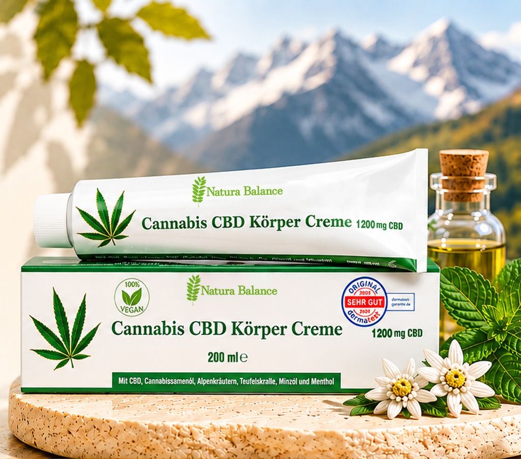 Natura Balance Cannabis CBD Körper Creme Tube und Faltschachtel vor Bergkulisse, mit Ölflasche und Blume.