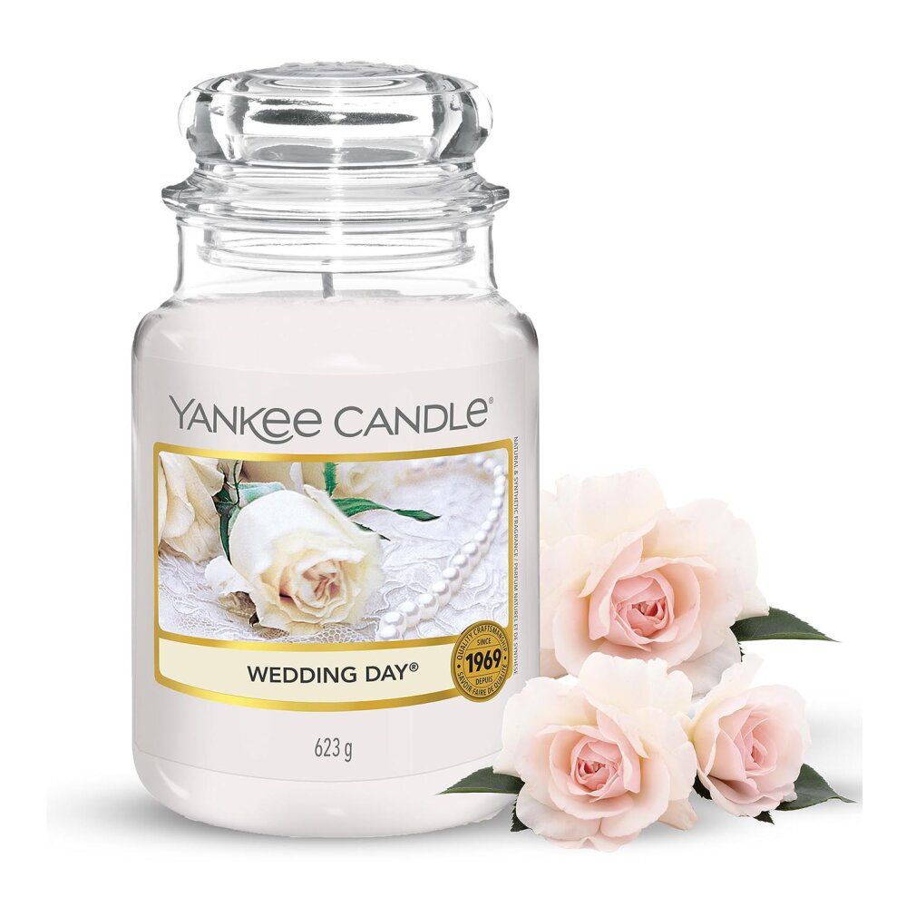 Kerze im Glas mit Deckel. Aufschrift: Yankee Candle Wedding Day. Etikett mit Rosenmotiv. 3 Rosen daneben.